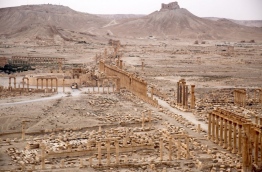 A picture taken from a helicopter during a press tour provided by the Russian Armed Forces on September 15, 2017 shows an aerial view of the ruins of Great Colonnade of the ancient city of Palmyra, in Syria's central province of Homs, with the Fakhr-al-Din al-Ma'ani Castle, known as Palmyra citadel, appearing in the background. / AFP PHOTO / France2 / Dominique DERDA