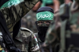 Masked youth cadets from the Ezzedine al-Qassam Brigades, the armed wing of the Palestinian Islamist Hamas movement, march in the southern Gaza Strip city of Khan Yunis on September 15, 2017. / AFP PHOTO / SAID KHATIB