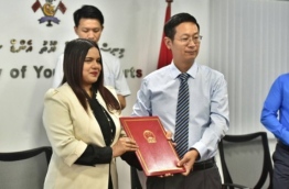 Chinese Ambassador Zhang Lizhong presents cheque on behalf of Chinese government Sports Minister Iruthisham Adam: the aid will be used to procure equipment for sports associations and centres. PHOTO: HUSSAIN WAHEED/MIHAARU