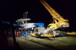 A crane hoists up the seaplane which crash landed in Hulhule lagoon due to strong turbulence. PHOTO/READER