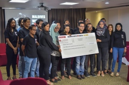 Staff of Raajje TV pose with a check of over MVR 5 million raised by the station to relieve the plight of the Rohingya. PHOTO: HUSSAIN WAHEED/MIHAARU