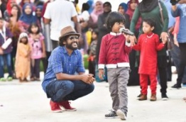 Kuda Ibbe watches as children sing at the Sports Stars Fiesta at Maafushi. PHOTO: HUSSAIN WAHEED/MIHAARU