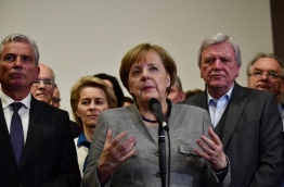 Tough talks to form Germany's next government stretched into overtime, putting Chancellor Angela Merkel's political future in the balance since failure to produce a deal could force snap elections. / AFP PHOTO / Tobias SCHWARZ