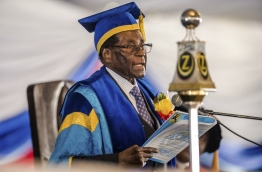 Zimbabwean President Robert Mugabe attended a university graduation ceremony today, making a defiant first public appearance since the military takeover that appeared to signal the end of his 37-year reign. / AFP PHOTO / Jekesai NJIKIZANA