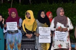 MDP supporters hold placards against the Maldives-China FTA outside MDP's main hub during an opposition rally. PHOTO: HUSSAIN WAHEED/MIHAARU