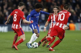 Chelsea's Brazilian midfielder Willian (C) is marked by Atletico Madrid's Spanish midfielder Saul Niguez (L) and Atletico Madrid's Brazilian defender Filipe Luis during a UEFA Champions League Group C football match between Chelsea and Atletico Madrid at Stamford Bridge in London on December 5, 2017. / AFP PHOTO / Ian KINGTON