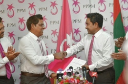 Moosa Manik (L) shakes hands with President Abdulla Yameen after signing into PPM. FILE PHOTO/MIHAARU