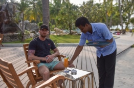 An employee of Sun Island Resort serves a drink to a tourist. PHOTO: HUSSAIN WAHEED/MIHAARU