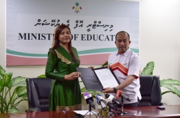 Education minister Dr Aishath Shiham (L) and EMGC's CEO Naudheen Thaajudheen pose for picture with agreement offering 500 higher education scholarships from Malaysia to the Maldives. PHOTO: HUSSAIN WAHEED/MIHAARU