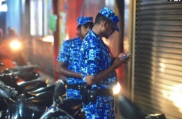 Two police officers wait outside a building in the capital Male while a team of police officers searched an apartment in the building on January 30, 2018, in relation to an incident encouraging paedophilia online. MIHAARU PHOTO / NISHAN ALI