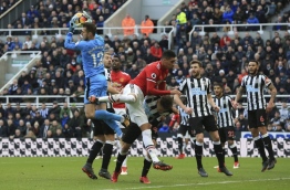 Newcastle United's Slovak goalkeeper Martin Dubravka (L) claims the ball in front of Manchester United's English defender Chris Smalling (C) during the English Premier League football match between Newcastle United and Manchester United at St James' Park in Newcastle-upon-Tyne, north east England on February 11, 2018. / AFP PHOTO / Lindsey PARNABY / RESTRICTED TO EDITORIAL USE. No use with unauthorized audio, video, data, fixture lists, club/league logos or 'live' services. Online in-match use limited to 75 images, no video emulation. No use in betting, games or single club/league/player publications. /