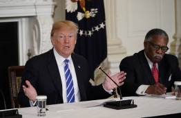 US President Donald Trump takes part in a meeting on infrastructure with state and local officials in the State Dining Room of the White House on February 12, 2018 in Washington, DC. At right is Vicksburg, Mississippi, Mayor George Flaggs. / AFP PHOTO / Mandel NGAN
