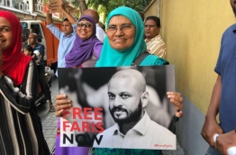 Former President Mohamed Nasheed's mother pictured holding a poster calling for the release of former President Maumoon Abdul Gayoom's son, Faris, during the opposition rally on March 2, 2018. PHOTO/SOCIAL MEDIA