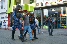 Riot police officers taking an opposition activist away from the crowds gathered at different parts of capital Male's main road Majeedhee Magu on March 2, 2018. MIHAARU PHOTO / HUSSEN WAHEED