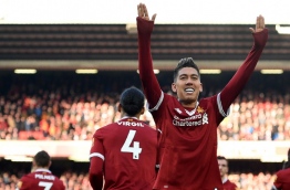 Liverpool's Brazilian midfielder Roberto Firmino celebrates scoring the team's third goal during the English Premier League football match between Liverpool and West Ham United at Anfield in Liverpool, north west England on February 24, 2018. / AFP PHOTO / Oli SCARFF / RESTRICTED TO EDITORIAL USE. No use with unauthorized audio, video, data, fixture lists, club/league logos or 'live' services. Online in-match use limited to 75 images, no video emulation. No use in betting, games or single club/league/player publications. /