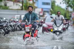 Motorcyclists drive along a flooded street in Male after a heavy rainstorm. PHOTO/MIHAARU