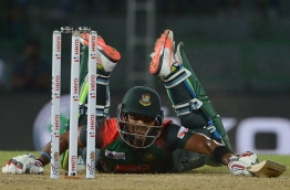 Bangladesh cricketer Sabbir Rahman successfully dives and avoids being run out during the Fifth Match, Nidahas Twenty20 Tri-Series international cricket match between India and Bangladesh at the R. Premadasa stadium in Colombo on March 14, 2018. / AFP PHOTO / LAKRUWAN WANNIARACHCHI