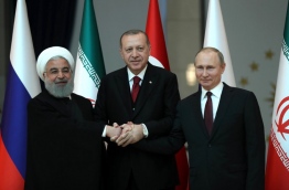 Turkish President Recep Tayyip Erdogan (C), Russian President Vladimir Putin (R) and President of Iran, Hassan Rouhani (L) pose for a photo ahead of the Turkey-Russia-Iran Tripartite summit in Ankara, Turkey on April 04, 2018. / AFP PHOTO / POOL / TOLGA BOZOGLU