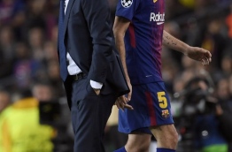 Barcelona's Spanish midfielder Sergio Busquets (R) walks past Barcelona's Spanish coach Ernesto Valverde as he leaves the pitch during the UEFA Champions League quarter-final first leg football match between FC Barcelona and AS Roma at the Camp Nou Stadium in Barcelona on April 4, 2018. / AFP PHOTO / LLUIS GENE