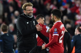Liverpool's German manager Jurgen Klopp (L) gestures with Liverpool's English midfielder Alex Oxlade-Chamberlain at the final whistle during the UEFA Champions League first leg quarter-final football match between Liverpool and Manchester City, at Anfield stadium in Liverpool, north west England on April 4, 2018. / AFP PHOTO / Anthony Devlin