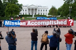 US President Donald Trump on April 15, 2018, defended his having hailed a US and allied strike in Syria as "Mission Accomplished." The phrase immediately evoked former president George W. Bush's premature Iraq victory speech on board the aircraft carrier USS Abraham Lincoln on May 1, 2003. A banner proclaiming "Mission Accomplished" loomed in the background as Bush declared the end of major combat operations in Iraq, a claim belied by the years of hard fighting that followed. / AFP PHOTO / Paul J. RICHARDS