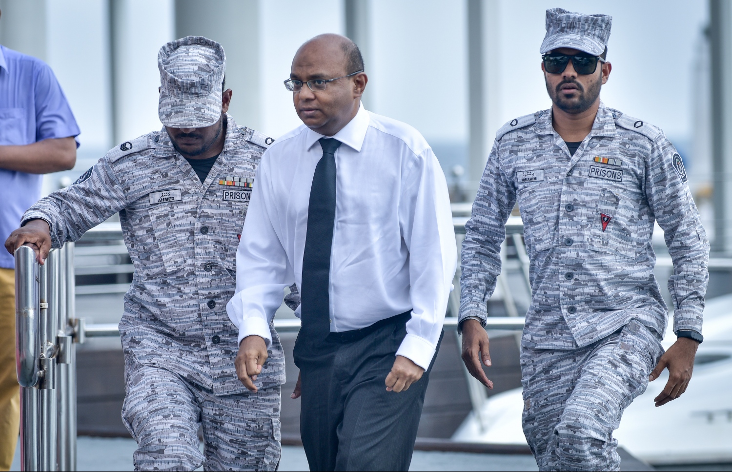 ކްރިމިނަލް ކޯޓުގައި އިއްޔެ ބޭއްވި ޝަރީއަތަށް، ކަރެކްޝަނަލް ސާވިސްގެ އޮފިސަރުންގެ ބެލުމުގެ ދަށުން އުއްތަމަ ފަނޑިޔާރު އަބްދުﷲ ސައީދު ގެންދަނީ.---ފޮޓޯ: ހުސެއިން ވަހީދު/މިހާރު