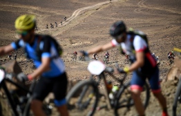 Competitors carry their bikes as they walk, during stage 6 of the 13th edition of the Titan Desert 2018 mountain biking race between Merzouga and Maadid on May 4, 2018. 
The Titan Desert 2018 is a 600 kilometres mountain bike race completed over six days, snaking between Boumalne Dades, at the foot-slopes of the High Atlas summits, and Erfoud, an oasis town in the Sahara Desert. / AFP PHOTO / FRANCK FIFE