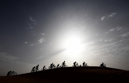 Competitors push their bikes up a sand dune during Stage 5 of the 13th edition of Titan Desert 2018 mountain biking race around Merzouga in Morocco on May 3, 2018. 
The Titan Desert 2018 is 600 kilometre mountain bike race completed over six days, snaking between Boumalne Dades, at the foot-slopes of the High Atlas summits, and Erfoud, an oasis town in the Sahara Desert. / AFP PHOTO / FRANCK FIFE
