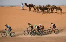 Competitors ride their bikes during Stage 5 of the 13th edition of Titan Desert 2018 mountain biking race around Merzouga in Morocco on May 3, 2018. The Titan Desert 2018 is 600 kilometre mountain bike race completed over six days, snaking between Boumalne Dades, at the foot-slopes of the High Atlas summits, and Erfoud, an oasis town in the Sahara Desert.