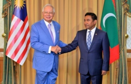 President Yameen Abdul Gayoom (R) shakes hands with outgoing Malaysia PM Najib Razak