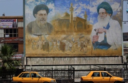 A poster shows Shiite leader Moqtada al-Sadr (L) and cleric Mohammed Baqer al-Sadr in Sadr City, east of the Iraqi capital Baghdad on May 14, 2018.
In the impoverished stronghold of Iraqi cleric Moqtada Sadr in Baghdad, supporters of the Shiite populist are hopeful for improvements as results put him on top in parliament elections.  / AFP PHOTO / AHMAD AL-RUBAYE