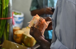 Man holding MVR 500 banknotes. PHOTO: HUSSAIN WAHEED / MIHAARU