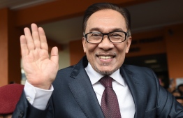 Jailed former opposition leader and current federal opposition leader Anwar Ibrahim greets supporters after his release from the Cheras Hospital Rehabilitation in Kuala Lumpur on May 16, 2018.
The release of Anwar from prison marks yet another sharp turn in a roller-coaster political life that has left a profound mark on Malaysian politics and society. Anwar was pardoned and released on May 16 after serving three years for a sodomy conviction widely considered a railroad job and now quashed following the stunning defeat of a Malaysian regime that had ruled for six decades.
 / AFP PHOTO / MOHD RASFAN