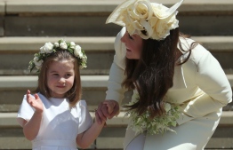 Princess Charlotte (L) waves by her mother Britain's Catherine, Duchess of Cambridge after attending the wedding ceremony of Britain's Prince Harry, Duke of Sussex and US actress Meghan Markle at St George's Chapel, Windsor Castle, in Windsor, on May 19, 2018. / AFP PHOTO / POOL / Jane Barlow