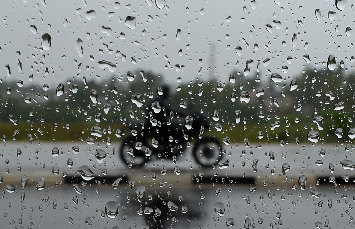 ވެރިރަށް ކޮލަމްބޯ އަށް ބޯކޮށް ވާރޭ ވެހެމުންދިޔަ އިރު މީހަކު ސައިކަލެއްގައި ދަނީ. --ފޮޓޯ:އޭއެފްޕީ