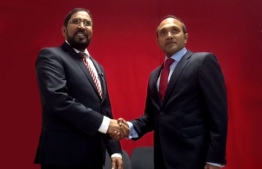 Qasim Ibrahim (L) and Dr. Mohamed Jameel shake hands during a meeting in Germany.