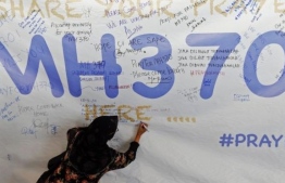 އެމްއެޗް370 އިން ދަތުކުރި މީހުންގެ އާއިލާތަކުން އެ މީހުންގެ ހަނދާނުގައި ބޭއްވި އިވެންޓެއްގައި މީހަކު ޝުއޫރު ފާޅުކޮށް ބިލްބޯޑެއްގައި ލިޔަނީ: ގެއްލިފައިވާ އެމްއެޗް370 ހޯދުމުގެ މަސައްކަތް މި މަހު އަލުން ފަށަން ވަނީ ނިންމާފައި. -- ފޮޓޯ: އޭއެފްޕީ