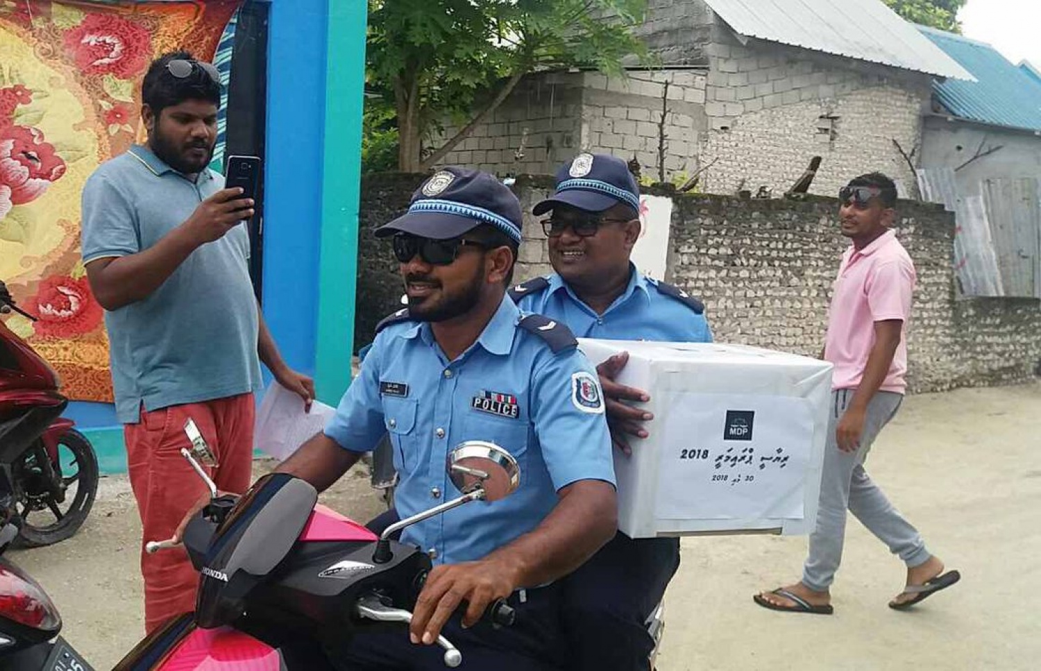 އެމްޑީޕީ ރިޔާސީ ޕްރައިމަރީގެ ވޯޓު ފޮއްޓެއް ހިފައިގެން ދެ ފުލުހަކު ސައިކަލްގައި ދަނީ.