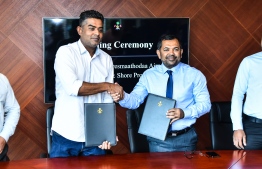 Tourism Minister Moosa Zameer (R) and Gulf Cobla Tennssor's Managing Director Ahmed Michael sign the contract awarding Gulf Cobla the project to reclaim land for G.Dh. Fares Maathodaa's domestic airport. PHOTO: AHMED NISHAATH/MIHAARU
