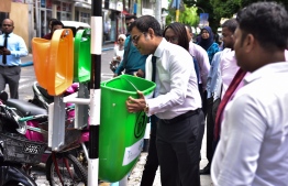 Environment Minister Thoriq Ibrahim placing a dustbin in Chaandhanee Magu to kick off the Road Side Dustbin Pilot Project 2018. PHOTO/AHMED NISHAATH