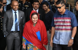 Rosmah Mansor (C), the wife of former Malaysian prime minister Najib Razak, leaves the Malaysian Anti-Corruption Commission headquarters after giving a statement in Putrajaya, on the outskirts of Kuala Lumpur, on June 5, 2018. / AFP PHOTO / Mohd RASFAN