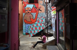 In this picture taken on June 1, 2018, an Indian girl sits near a mural in Mumbai.
Mumbai's slums are getting a colourful makeover thanks to an organisation that aims to change how people perceive deprived areas in India's financial capital. / AFP PHOTO / PUNIT PARANJPE