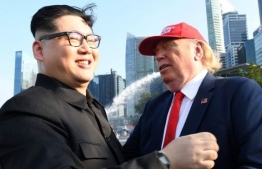 ޓްރަމްޕް ހެދިގެން އުޅޭ ޑެނިސް އެލަން (ކ) އާއި ކިމް 'ހެދިގެން' އުޅޭ ހާވަޑް އެކްސް. މި ދެވެރިން ސިންގަޕޫރަށް ގޮސް އުޅެނީ ހުނަރު ދައްކައިލާ ފޮޓޯ ނަގައިލަން. - ފޮޓޯ: އޭއެފްޕީ