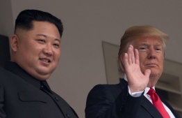 US President Donald Trump (R) waves as he and North Korea's leader Kim Jong Un look on from a veranda during their historic US-North Korea summit, at the Capella Hotel on Sentosa island in Singapore on June 12, 2018.
Donald Trump and Kim Jong Un have become on June 12 the first sitting US and North Korean leaders to meet, shake hands and negotiate to end a decades-old nuclear stand-off. / AFP PHOTO / SAUL LOEB