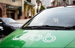 The logo of Southeast Asian ride-hailing company Grab is seen on the hood of a car in Singapore. PHOTO: ORE HUYING/BLOOMBERG/GETTY IMAGES.