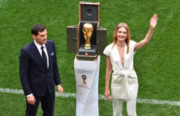 Russian model Natalia Vodianova (R) and Spanish goalkeeper Iker Casillas stand next to the World Cup trophy during the opening ceremony before the Russia 2018 World Cup Group A football match between Russia and Saudi Arabia at the Luzhniki Stadium in Moscow on June 14, 2018. / AFP PHOTO / Mladen ANTONOV / 