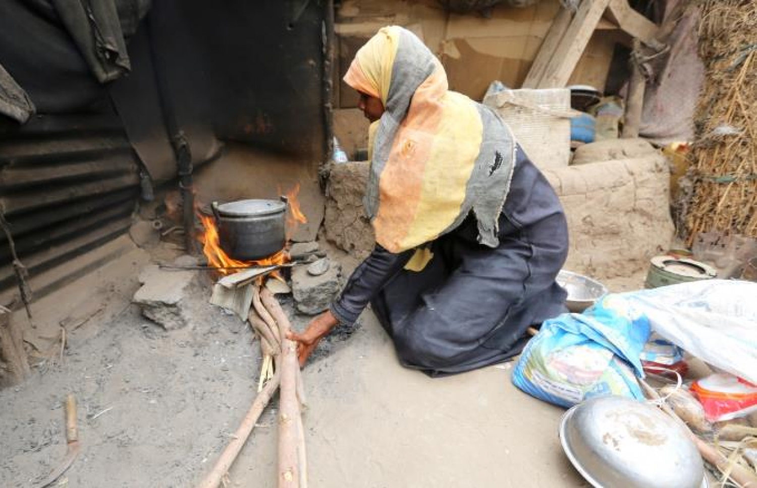 ޔަމަންގެ ހުދައިދާގެ ތެރޭގައި ތާށިވެ ހާލުގައި ޖެހިފައިވާ އާއިލާއެއްގެ އަންހެނަކު ކާތަކެތި ރޯފިލުވަނީ. ފޮޓޯ އަލް ޖަޒީރާ