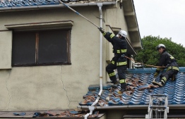 Firefighters check a house damaged by an earthquake in Ibaraki City, north of Osaka prefecture on June 18, 2018. 
A strong quake hit western Japan early June 18, but there were no immediate reports of major damage or risk of tsunami waves, officials said.  / AFP PHOTO / JIJI PRESS / STR / 