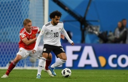 Russia's midfielder Yuri Gazinskiy (L) vies with Egypt's forward Mohamed Salah during the Russia 2018 World Cup Group A football match between Russia and Egypt at the Saint Petersburg Stadium in Saint Petersburg on June 19, 2018.  / AFP PHOTO / Olga MALTSEVA / 
