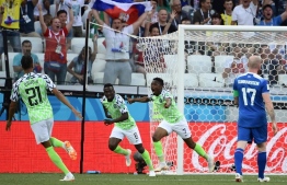 Nigeria's forward Ahmed Musa (R) celebrates past Nigeria's midfielder Oghenekaro Etebo (C) after scoring their opener during the Russia 2018 World Cup Group D football match between Nigeria and Iceland at the Volgograd Arena in Volgograd on June 22, 2018. / AFP PHOTO / NICOLAS ASFOURI / 